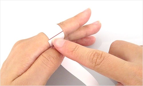 切った紙を指に巻いている写真